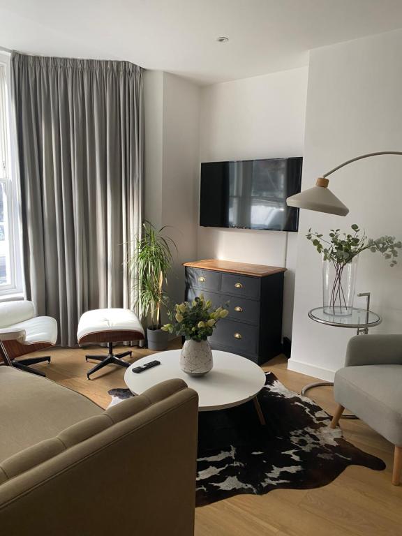 a living room with a couch and a table at Salt Life Contemporary Apartment in Brighton & Hove