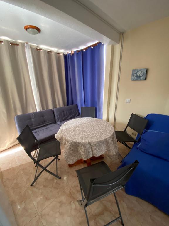 salon z kanapą, stołem i krzesłami w obiekcie STUDIO Gerona Playmon Virginia w mieście Benidorm
