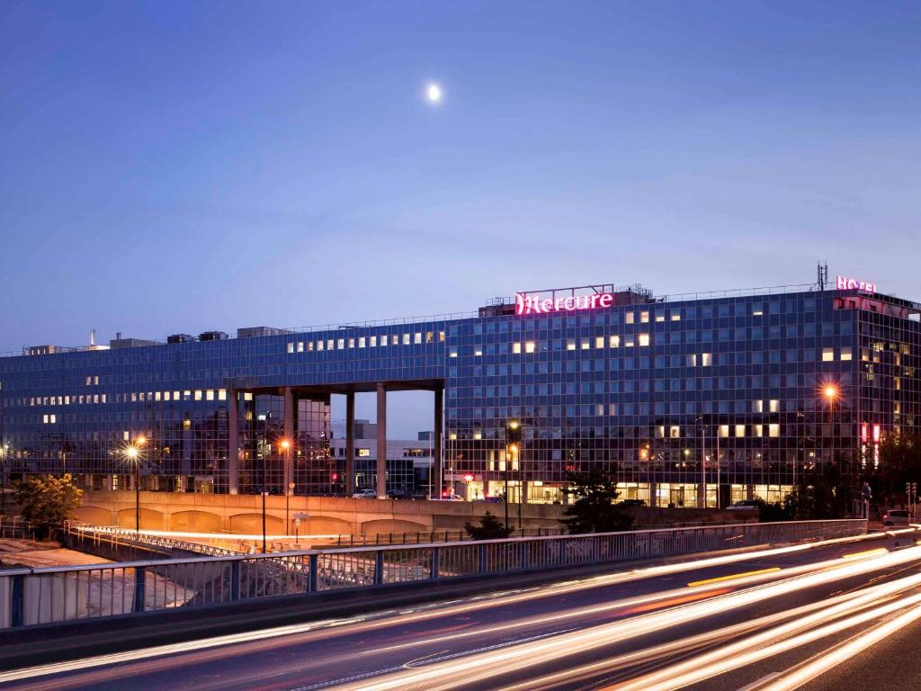 un gran edificio con un cartel encima en Mercure Paris Ivry Quai De Seine, en Ivry-sur-Seine