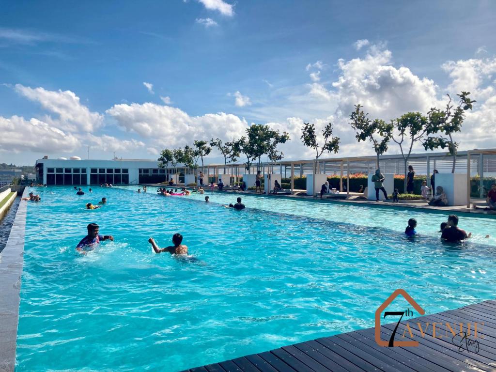 eine Gruppe von Personen, die in einem Schwimmbad schwimmen in der Unterkunft 7th Avenue Stay (Sutera Avenue) in Kota Kinabalu