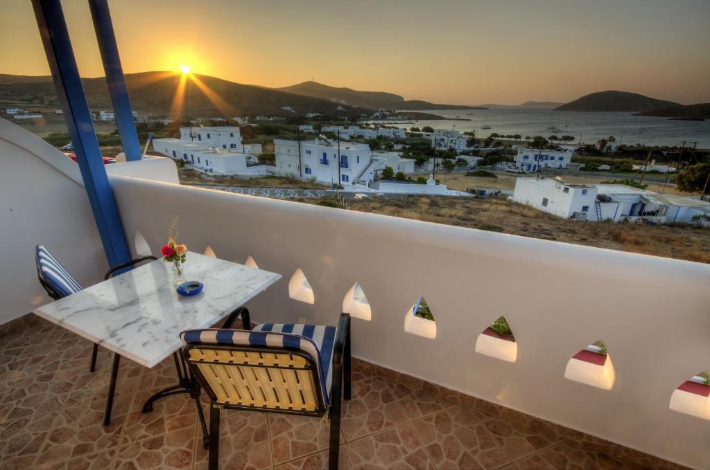 einen Balkon mit einem Tisch und Stühlen sowie Stadtblick in der Unterkunft Agnadi studios in Maltezana