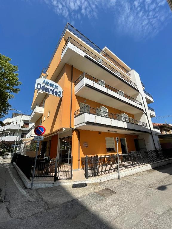 un edificio anaranjado con un cartel en el costado en Albergo Désirée 2, en Alba Adriatica