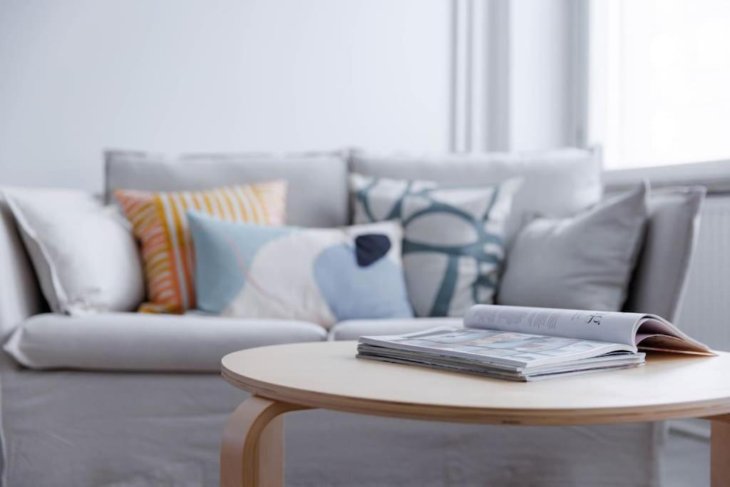 a living room with a couch and a table with a book at Studio for a business traveler in Helsinki