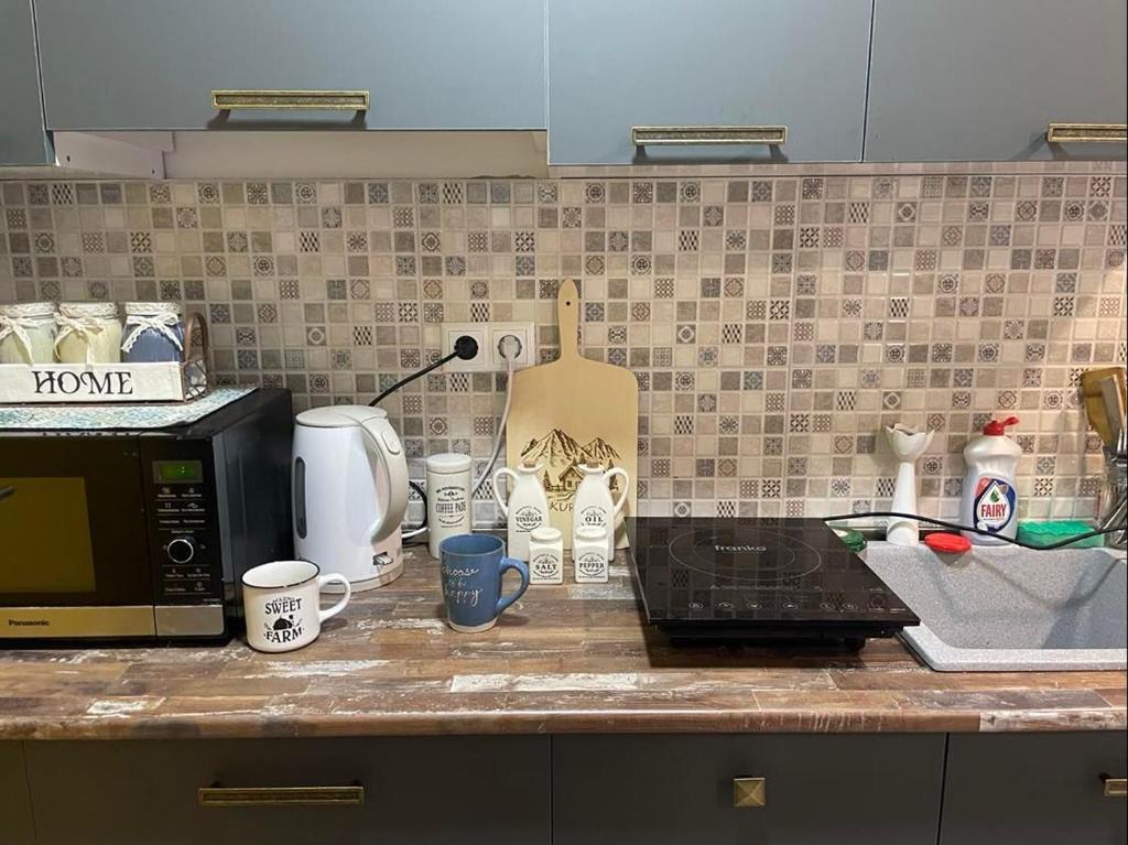a kitchen counter with a microwave and coffee cups at Bakuriani mix appartment in Bakuriani