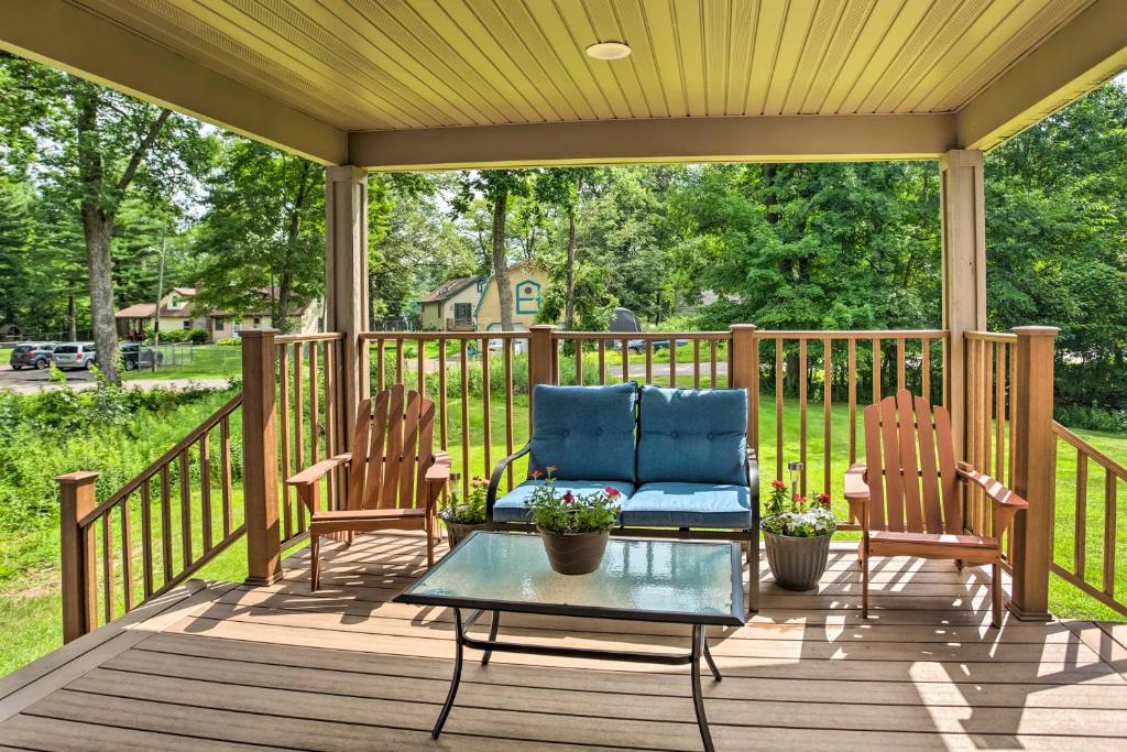 - une terrasse couverte avec 2 chaises et une table dans l'établissement Cabin with Dock and Porch Across from Balsam Lake, à Balsam Lake