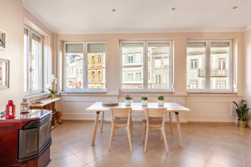 a kitchen with a table and chairs and windows at Charming 120m² in Historic Center in Lamego