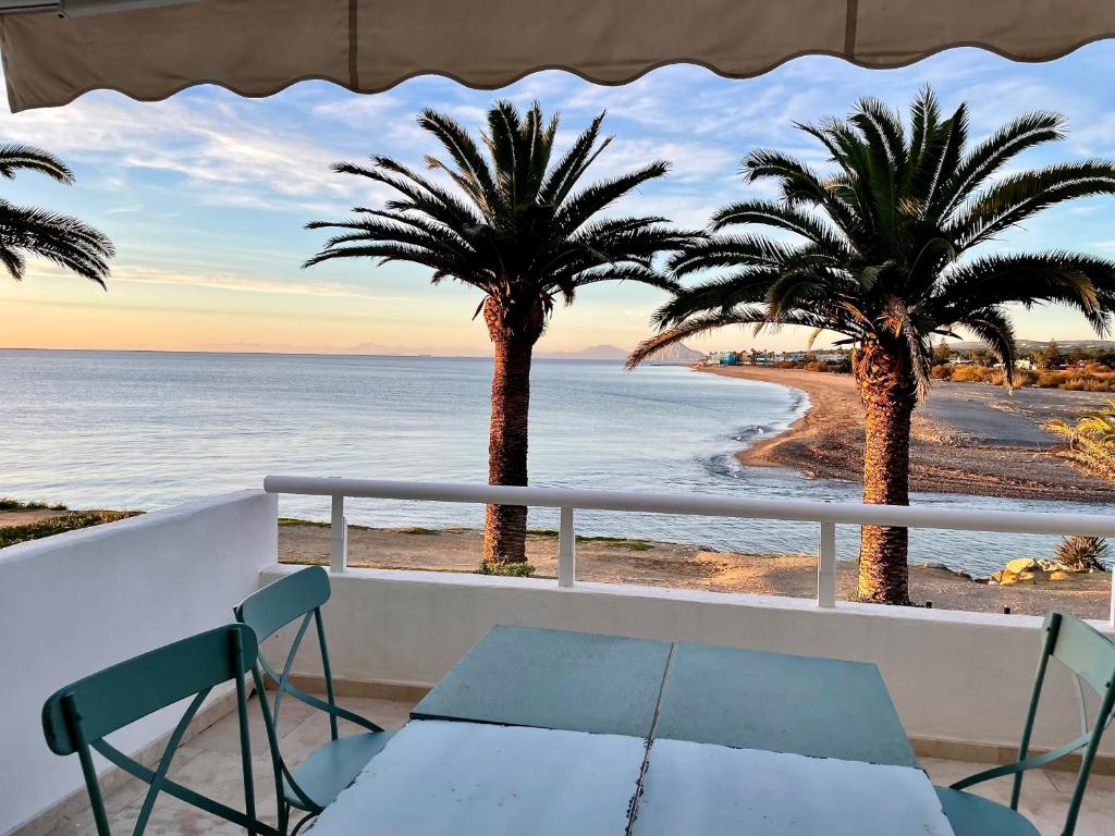 a view of the beach from a balcony with palm trees at Sotogrande Paseo del Rio in Sotogrande