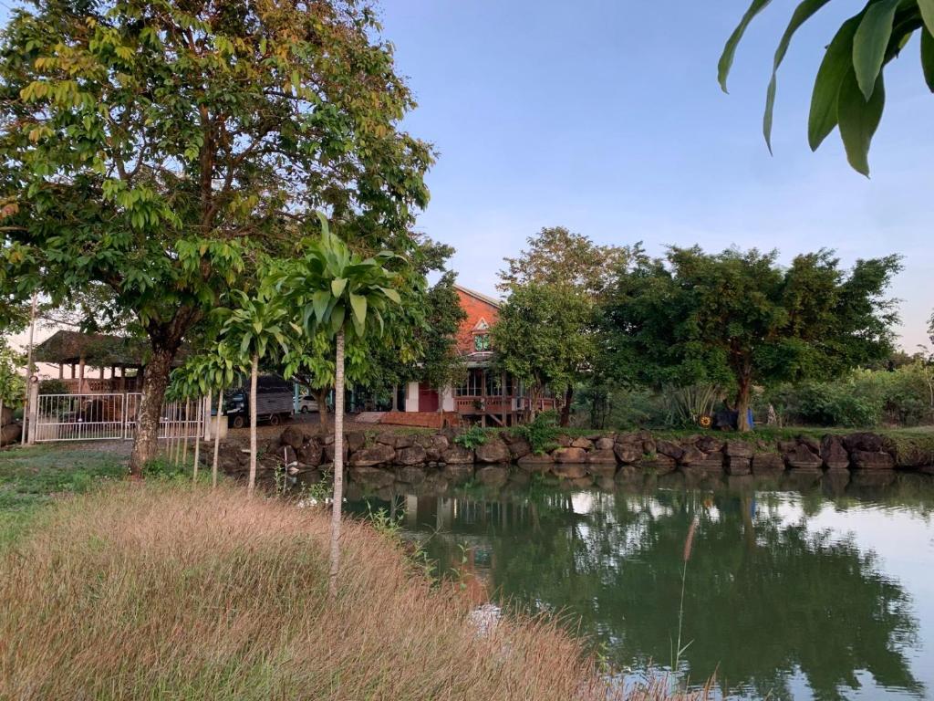 a house sitting next to a river with trees at Homestay tay in Xã Trảng Bôm