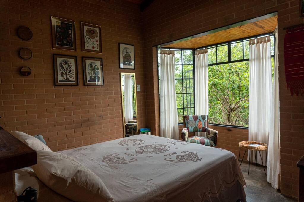 a bedroom with a bed and a large window at Segredo dos Pireneus in Pirenópolis