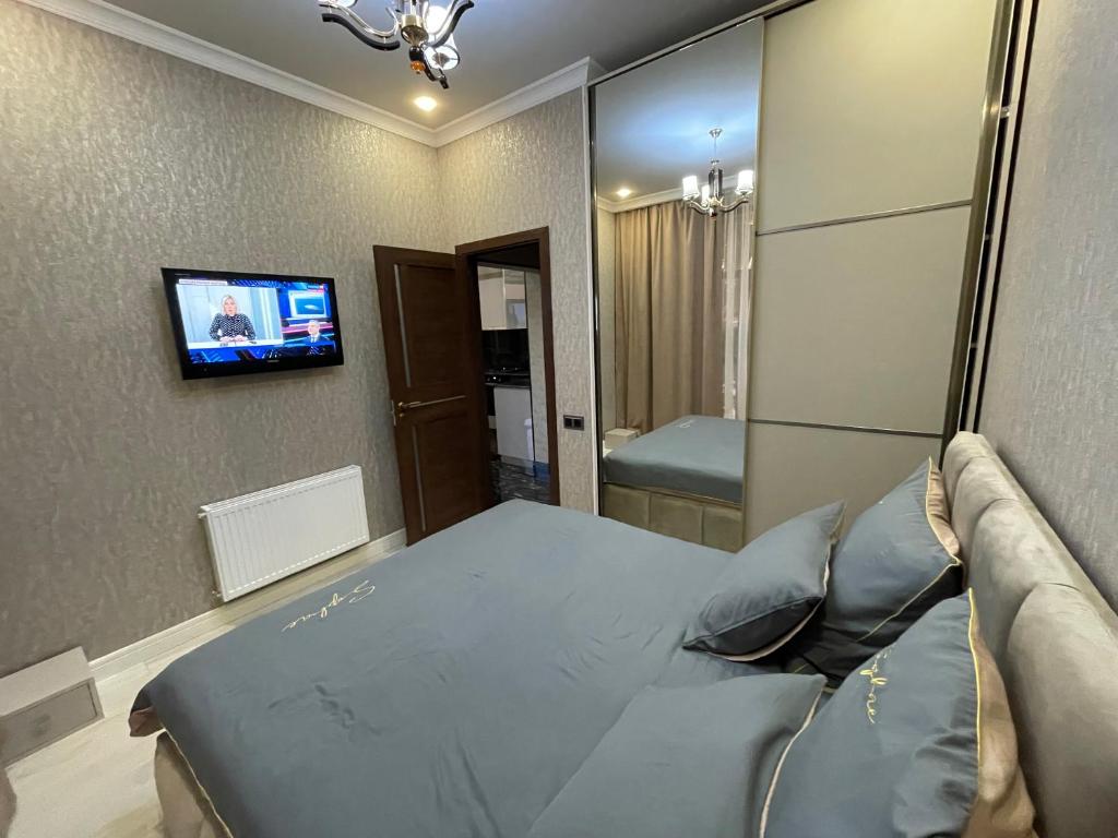 - une chambre avec un lit et une télévision murale dans l'établissement Apartments in the center of Gyumri, à Gyumri