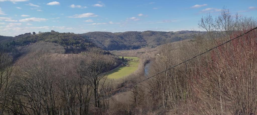a view of a river in a valley with trees at Château de Chauvac - Chambres et table d'hôtes avec vue sur la rivière in Bassignac-le-Bas