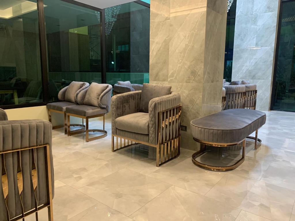 a lobby with chairs and a table in a building at Thana Wisut Hotel - SHA Plus in Bangkok