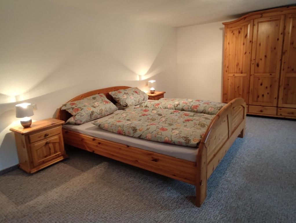una camera con letto in legno e 2 comodini di Geräumige Wohnung im Schwarzwald a Seelbach