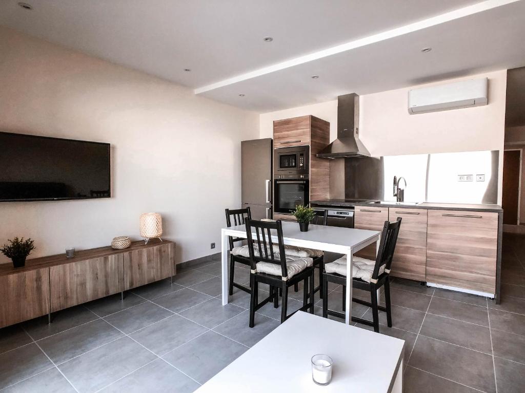 une cuisine et une salle à manger avec une table et des chaises dans l'établissement SCI LA VIEILLE, au Lavandou