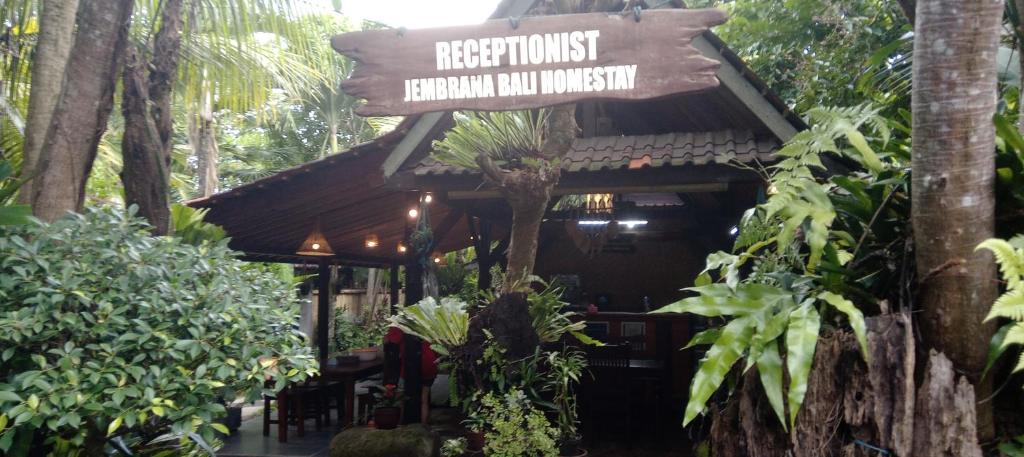 a restaurant in a forest with a sign on it at Jembrana Bali Homestay in Pengambengan