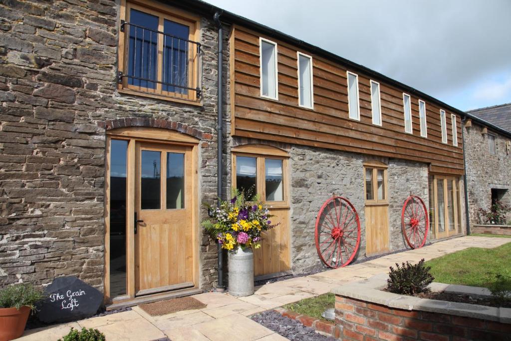 a brick building with wooden doors and windows at The Grain Loft in Clun