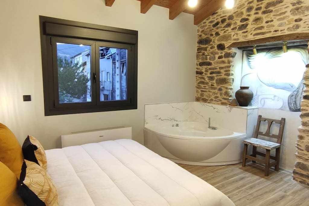 a bedroom with a bath tub and a large bed at Precioso Apartamento 2 Hab con Bañera Hidromasaje in O Barco de Valdeorras