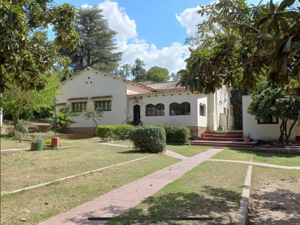 ein weißes Haus mit Bäumen im Hof in der Unterkunft Posada del Bosque in Tanti