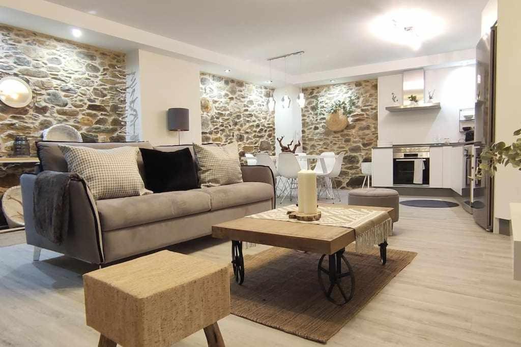 sala de estar con sofá y mesa en Precioso Apartamento 1 Hab con Bañera Hidromasaje, en O Barco de Valdeorras
