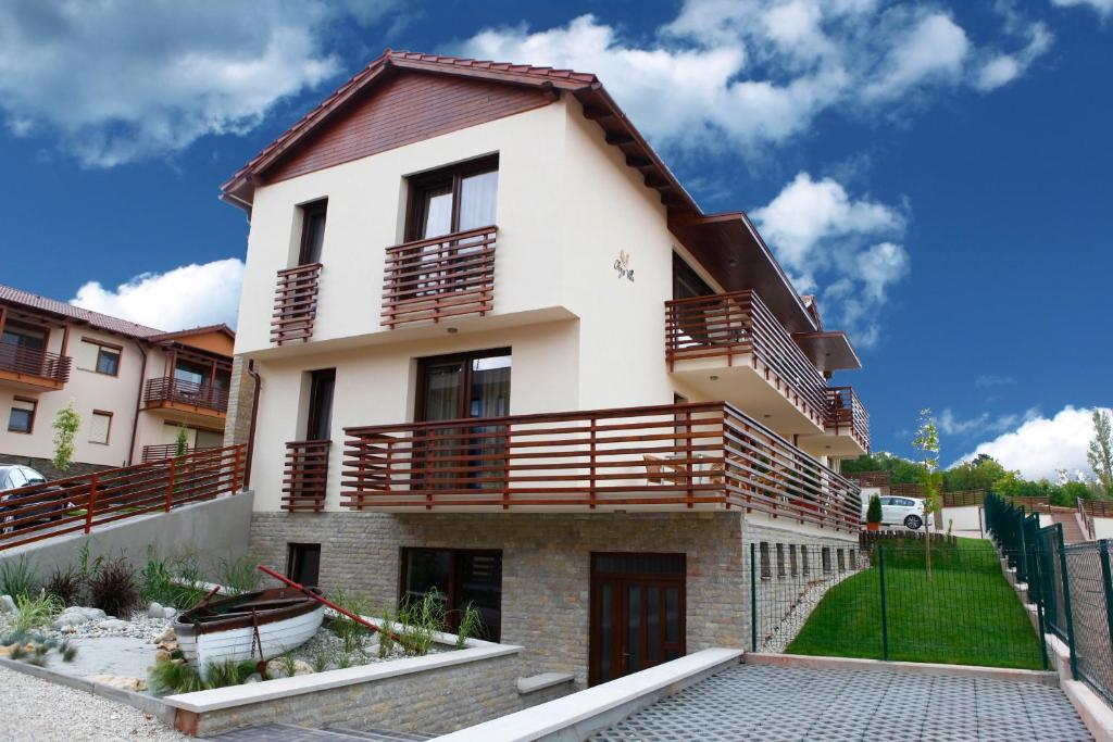 a house with wooden balconies on top of it at Fürjes Villa Apartmanház in Balatonfüred