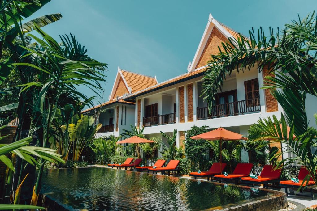 a resort with a swimming pool with chairs and umbrellas at Bopha Wat Bo Residence in Siem Reap