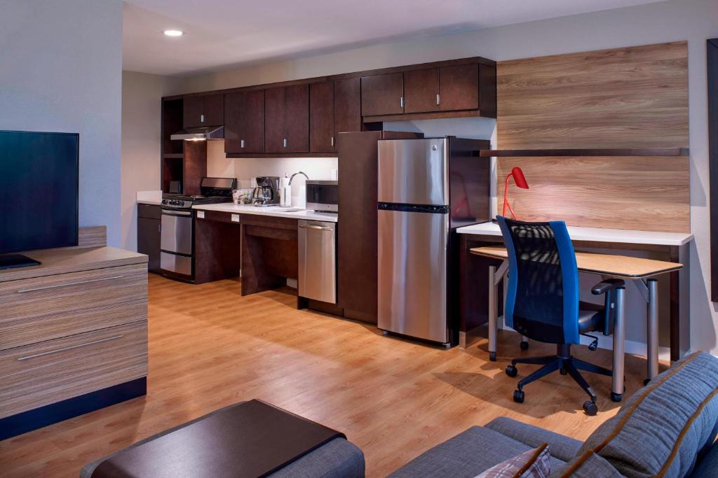リッチモンドにあるTownePlace Suites by Marriott Richmondのキッチン(デスク、冷蔵庫、テーブル付)