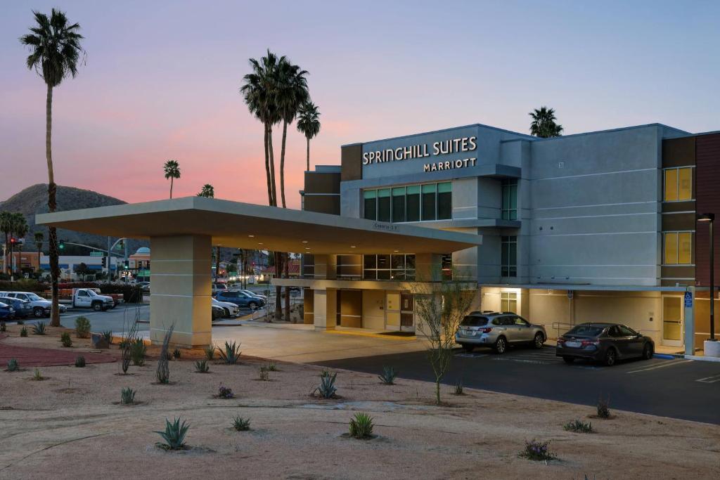 un bâtiment avec des voitures garées dans un parking dans l'établissement SpringHill Suites by Marriott Palm Desert, à Palm Desert