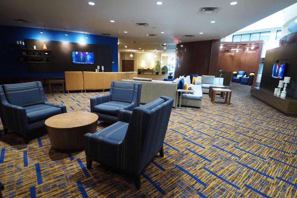a lobby with blue chairs and a waiting room at Courtyard by Marriott Columbus West/Hilliard in Columbus