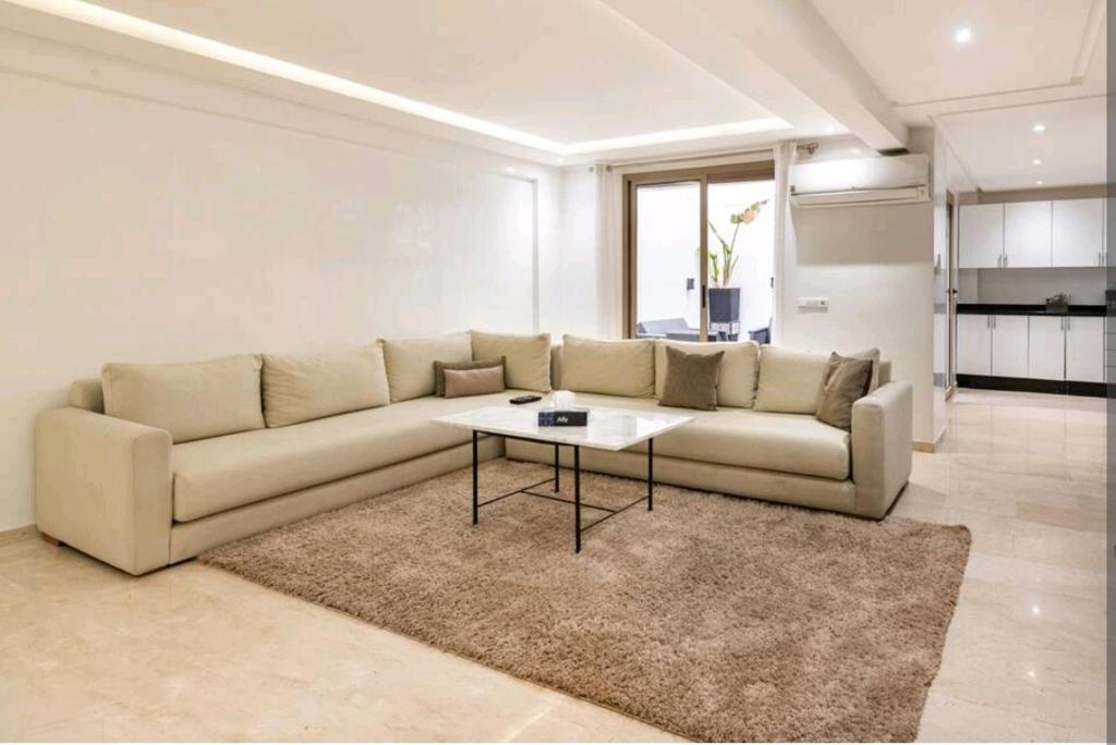 sala de estar con sofá y mesa en Duplex de luxe, en Marrakech