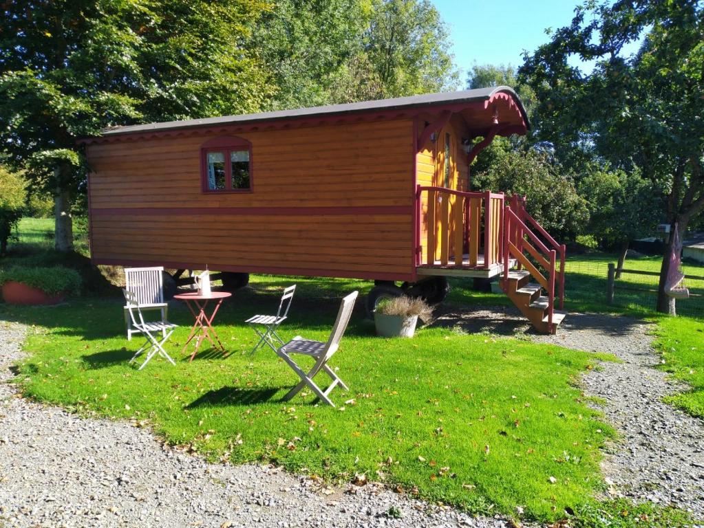 eine kleine Hütte mit einem Tisch und Stühlen im Hof in der Unterkunft Roulot'So Zen in Beslon