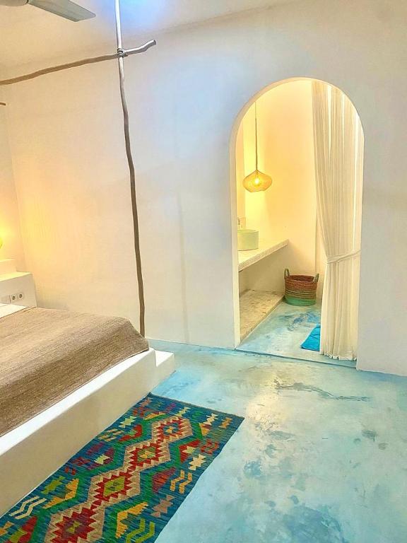 a bedroom with blue floors and a bed and a mirror at Guru Canggu in Canggu