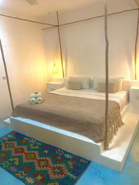 a bedroom with a large bed with two towels on it at Guru Canggu in Canggu
