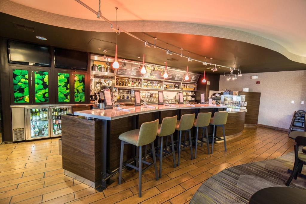 un bar en un restaurante con taburetes en Courtyard by Marriott Merced, en Merced