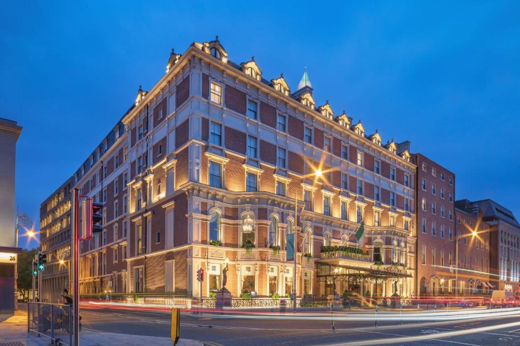 un gran edificio en la esquina de una calle por la noche en The Shelbourne, Autograph Collection, en Dublín