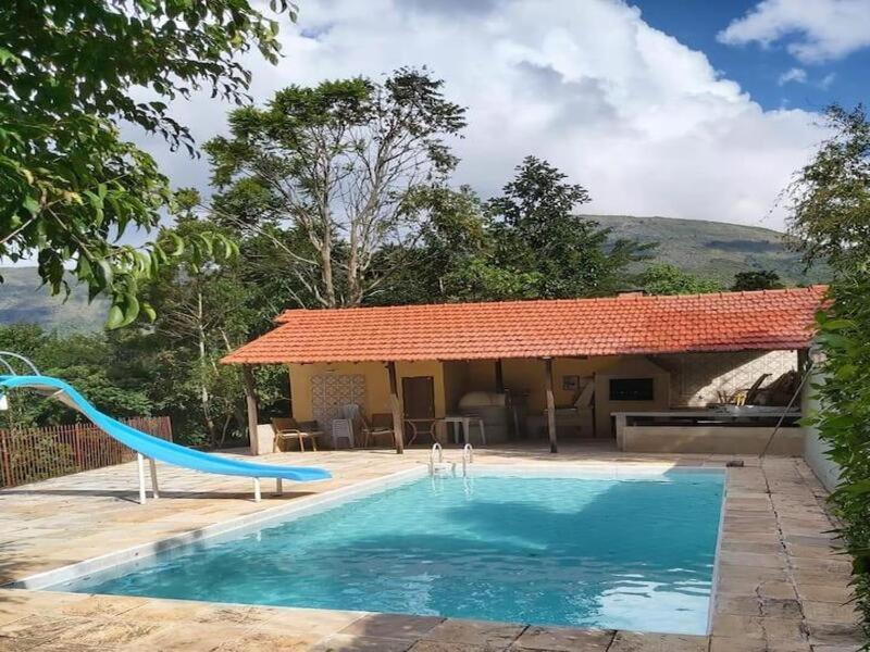 une piscine avec toboggan en face d'une maison dans l'établissement Casa acolhedora com lazer e espaço gourmet, à Petrópolis