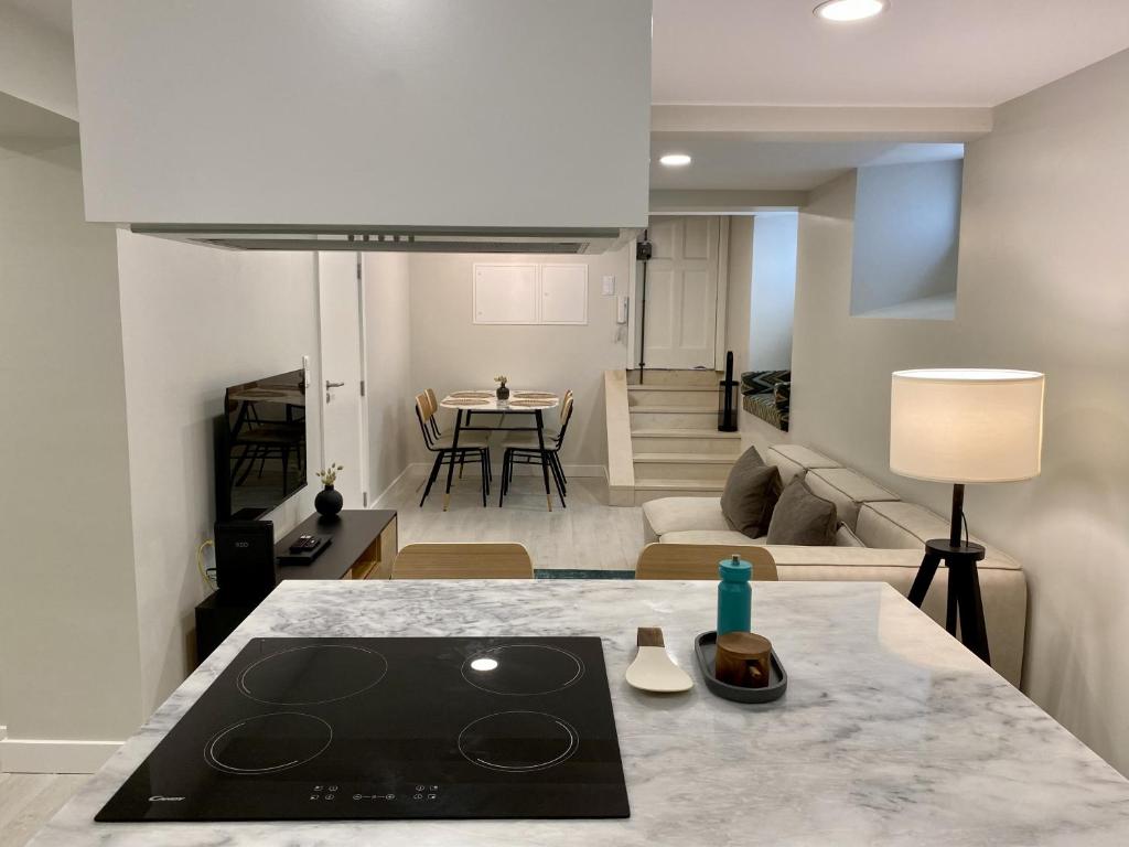 eine Küche und ein Wohnzimmer mit einer Arbeitsplatte in der Unterkunft Canarios Apartments Cardal - ll in Lissabon