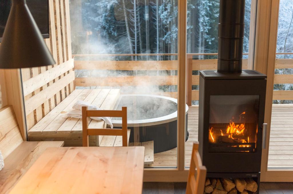 une cheminée sur une terrasse avec un bain à remous dans l'établissement Forstgut Luxuschalets, à Regen