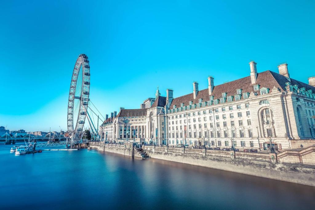 a river with a large building and a ferris wheel at London Marriott Hotel County Hall in London