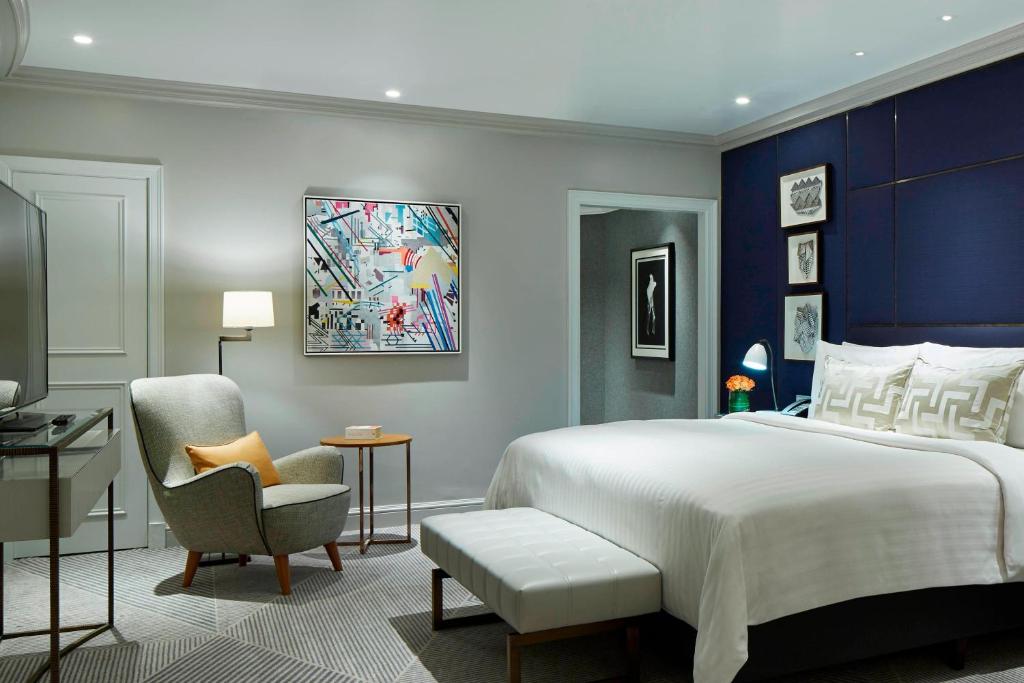a bedroom with a king sized bed and a chair at London Marriott Hotel County Hall in London