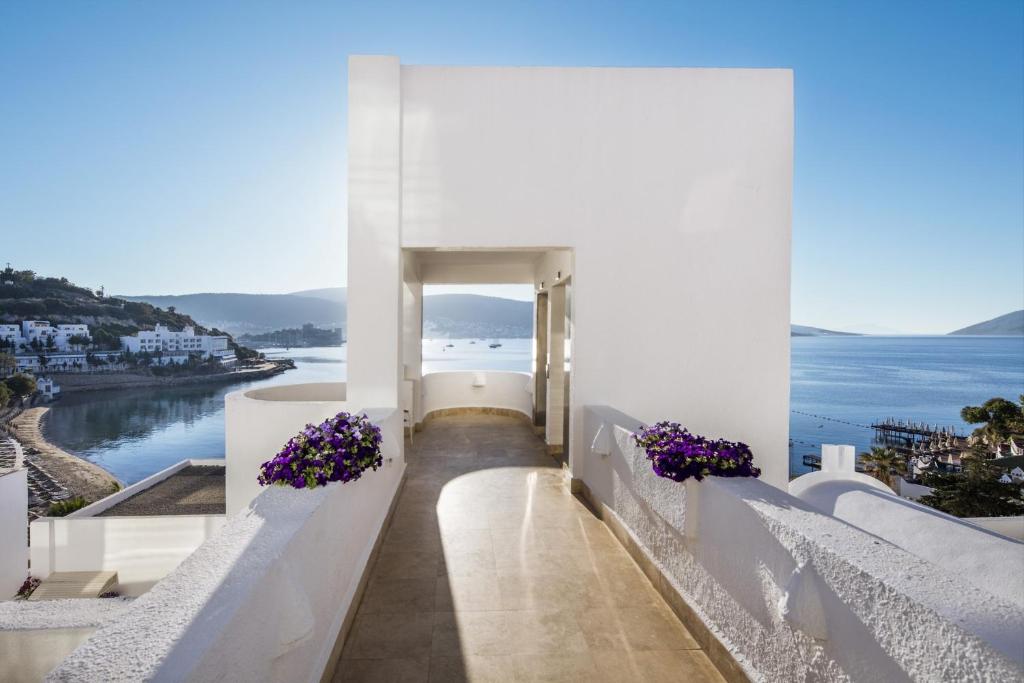 a view of the ocean from a white building with purple flowers at Prive Hotel Bodrum - Adult Only in Bodrum City