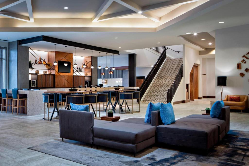 Marriott Dallas Las Colinas في ايرفينغ: غرفة معيشة مع أريكة ومطبخ