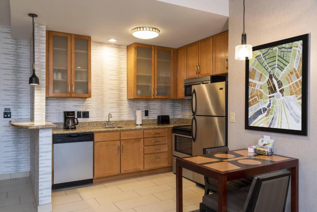 a kitchen with wooden cabinets and a stainless steel refrigerator at Residence Inn by Marriott Midland in Midland