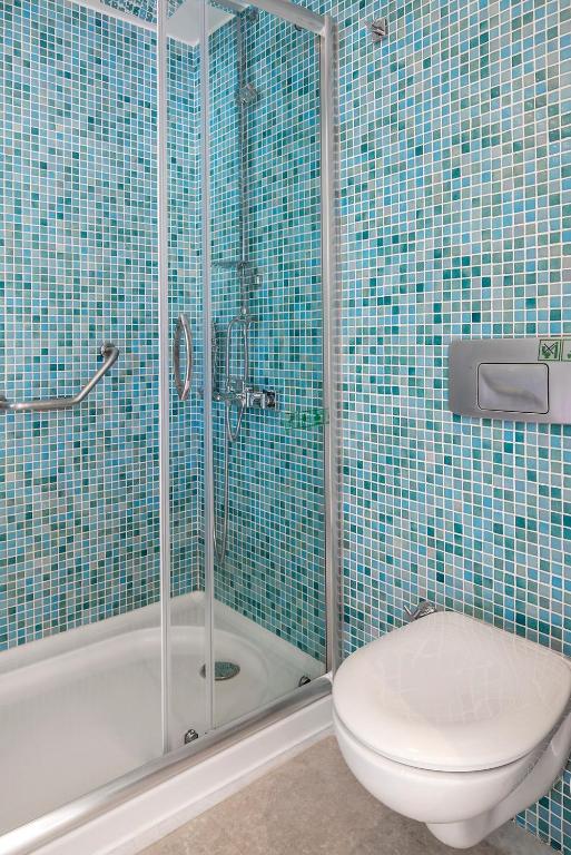 a blue tiled bathroom with a toilet and a shower at Prive Hotel Bodrum - Adult Only in Bodrum City