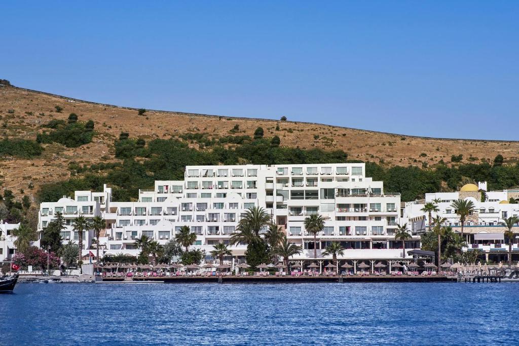 a large white building next to a body of water at Prive Hotel Bodrum - Adult Only in Bodrum City