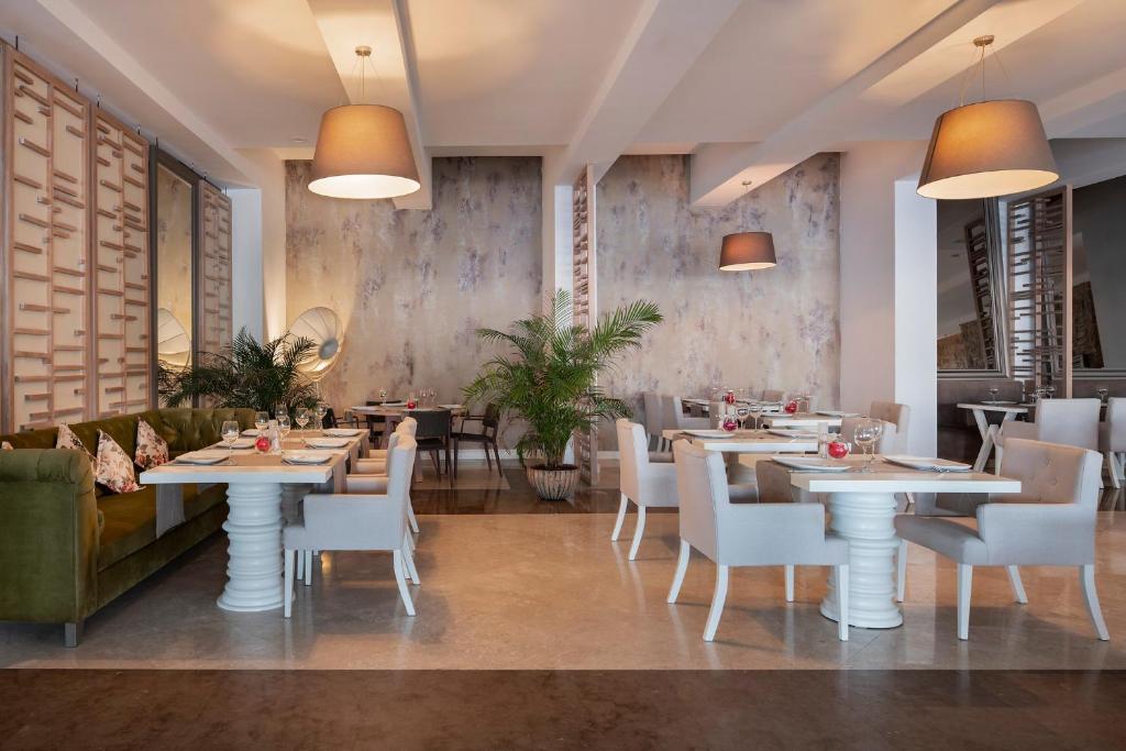 a restaurant with white tables and white chairs at Prive Hotel Bodrum - Adult Only in Bodrum City