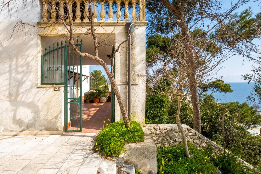 a door to a house with the ocean in the background at Bilocale - Rosa seaview in villa in Santa Cesarea Terme