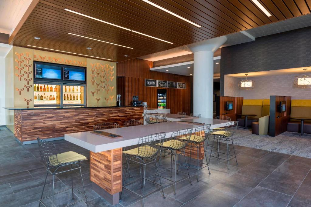 a restaurant with a bar with chairs and a table at Courtyard by Marriott Waterloo Cedar Falls in Waterloo