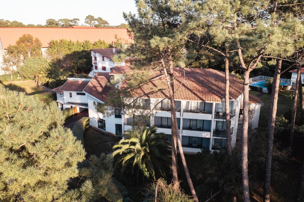 uma vista aérea de um grande edifício branco com árvores em Hôtel Les Fougères em Hossegor