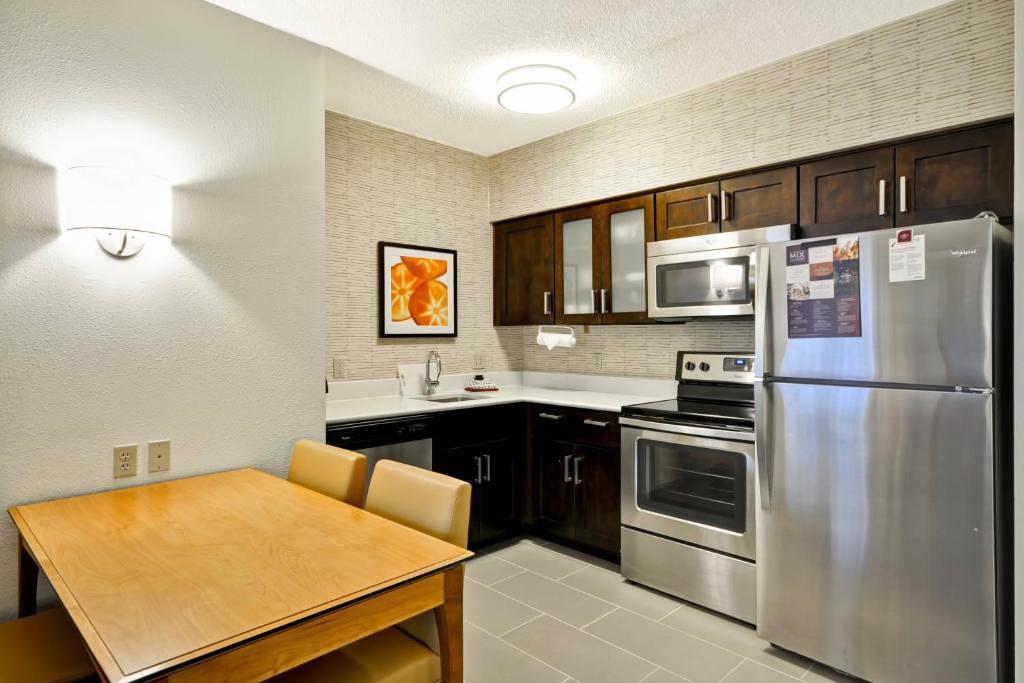 a kitchen with a table and a stainless steel refrigerator at Residence Inn Lexington South Hamburg Place in Lexington