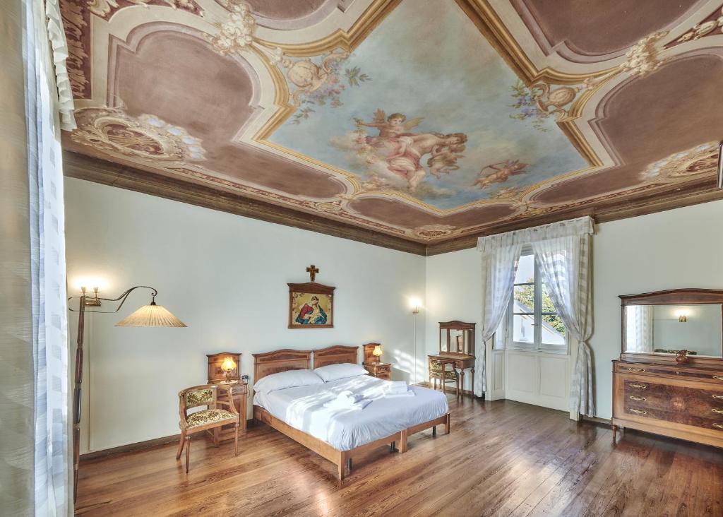a bedroom with a bed with a painting on the ceiling at Villa Ada Historic 800s in Mandello del Lario